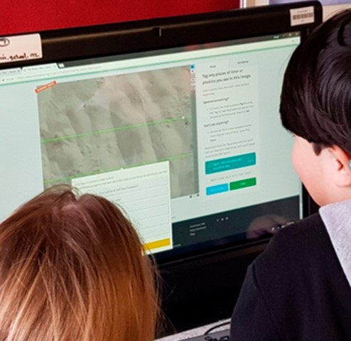 This is a photo of two children looking at a computer screen