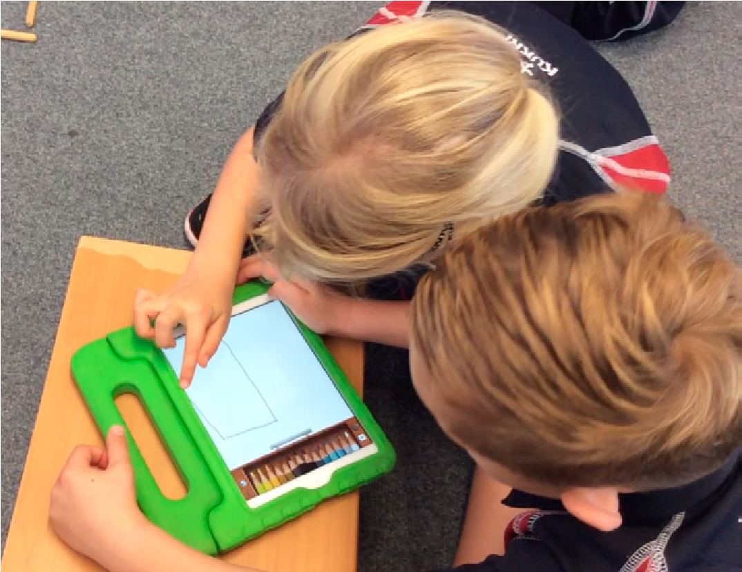 This is a picture of two children looking at a computer tablet