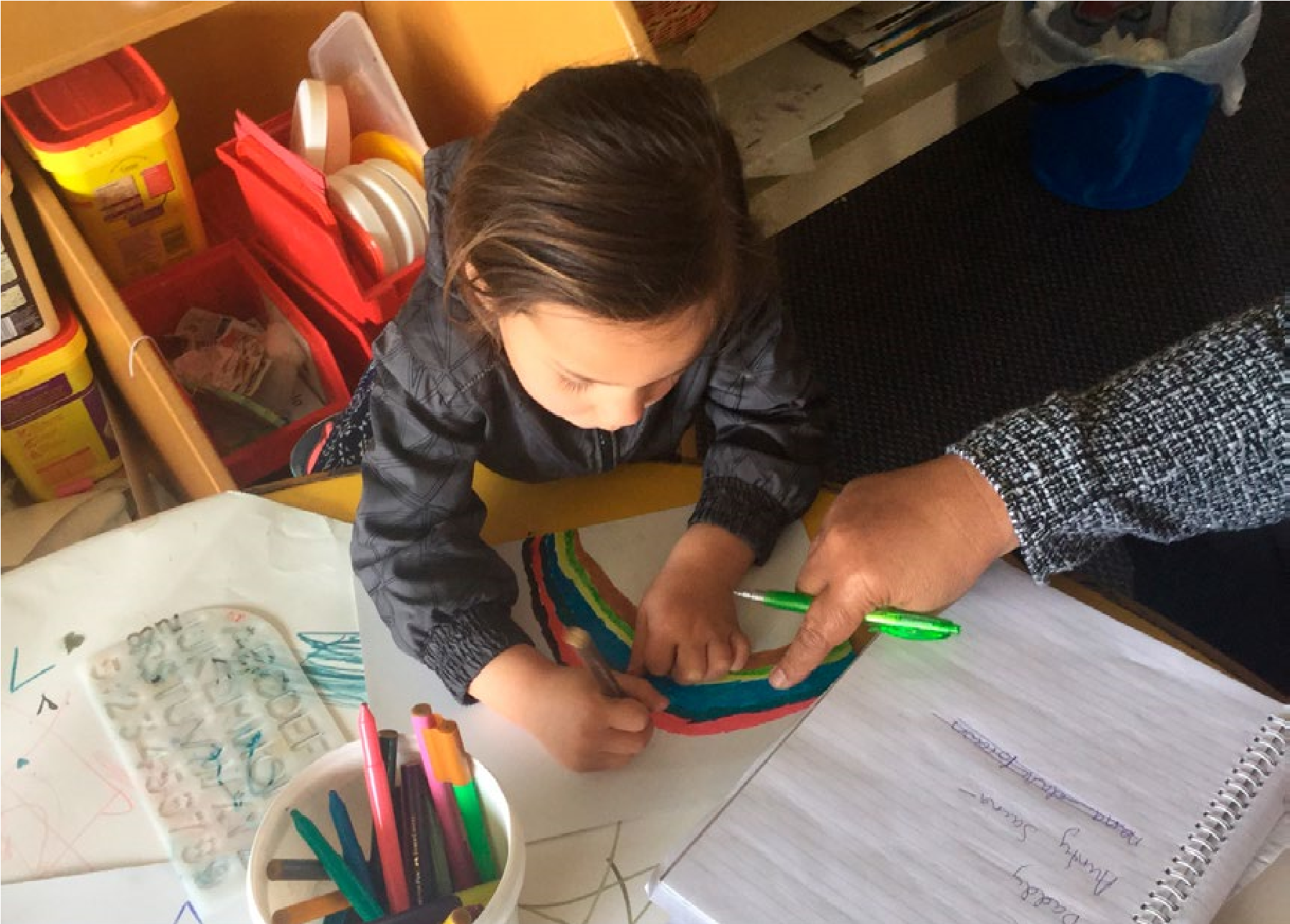 This is a picture of a girl drawing a rainbow