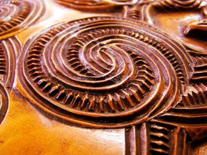 This is a photo of a takarangi, which is a wooden carving with a spiral motif