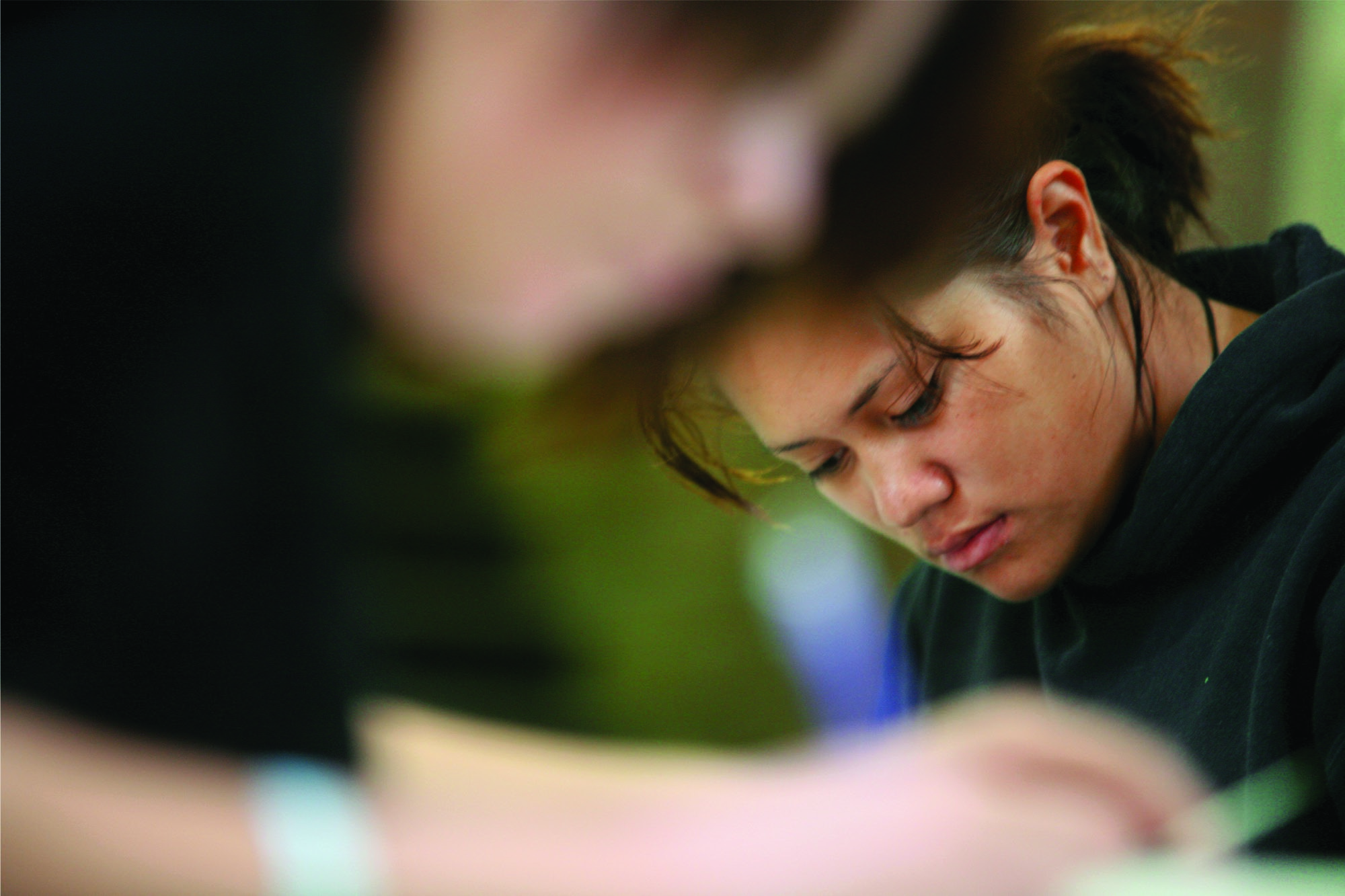 A close up photo of a student looking down and concentrating