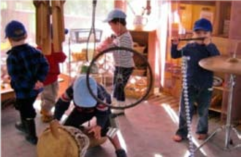 Another picture of children exploring. One is playing a drum