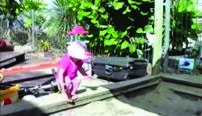 This is a picture of a child standing on the edge of a sandpit