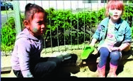 This is a picture of two children, sitting down outside