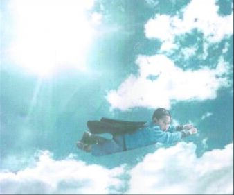 A photoshopped image of a young boy with a cape, flying through the air like Superman