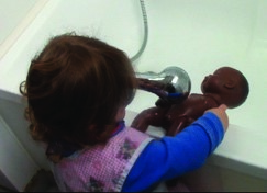 This is a photo of a girl bathing a doll