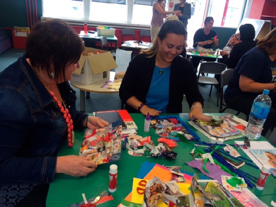 This is a photo of several teachers sitting at a table, completing their collages