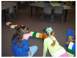 Two girls playing together on the mat