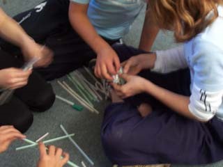 Students sitting on the matt working on a puzzle