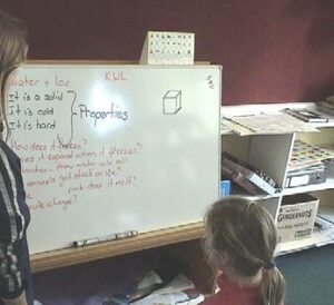 A student and teacher looking at a white board