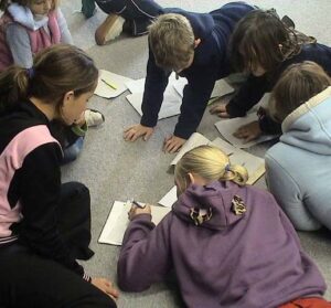 Four students sitting on the floor working on a problem