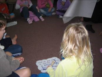 A circle of students sitting on the floor. One of them has their thought bubble in front of them