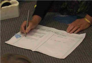 A picture of a teacher writing observations on a notebook