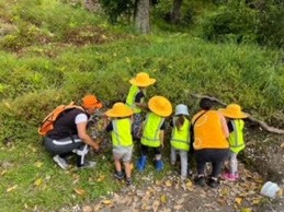 This is a photo of two kaiako and five tamariki exploring the bush