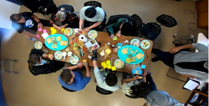 Aerial photo looking down on a group of people sitting at a table, sharing food